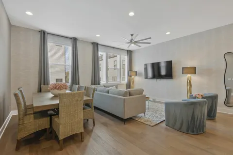 a living room with furniture a flat screen tv and wooden floor
