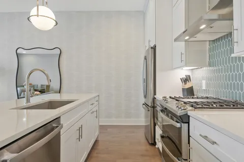a kitchen with granite countertop a sink stove and cabinets