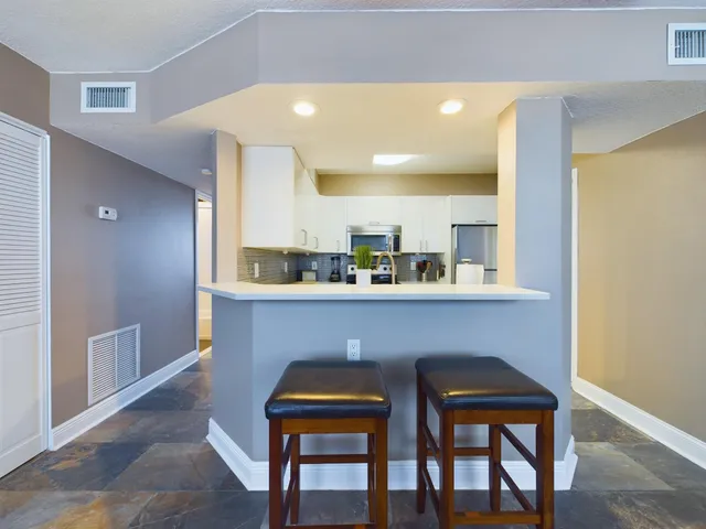 a room with two chairs and kitchen view