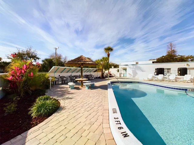 a swimming pool with barbeque oven and outdoor seating