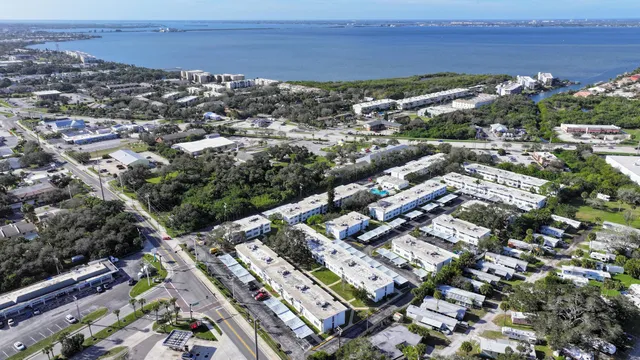 a front view of a house with a garden and trees