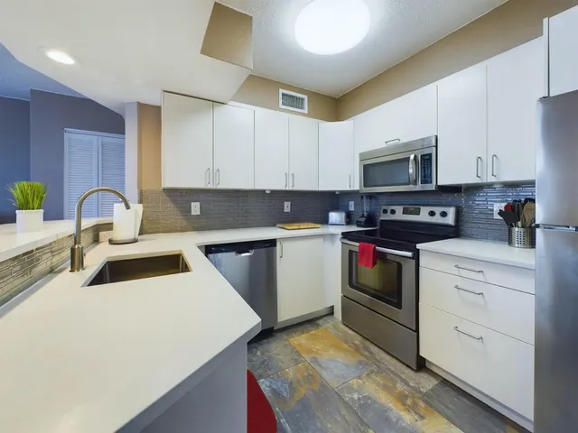a kitchen with stainless steel appliances a stove sink microwave and cabinets