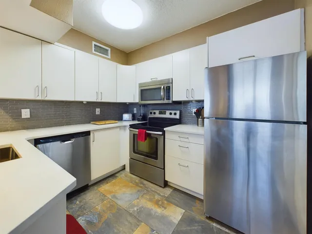 a kitchen with refrigerator and cabinets