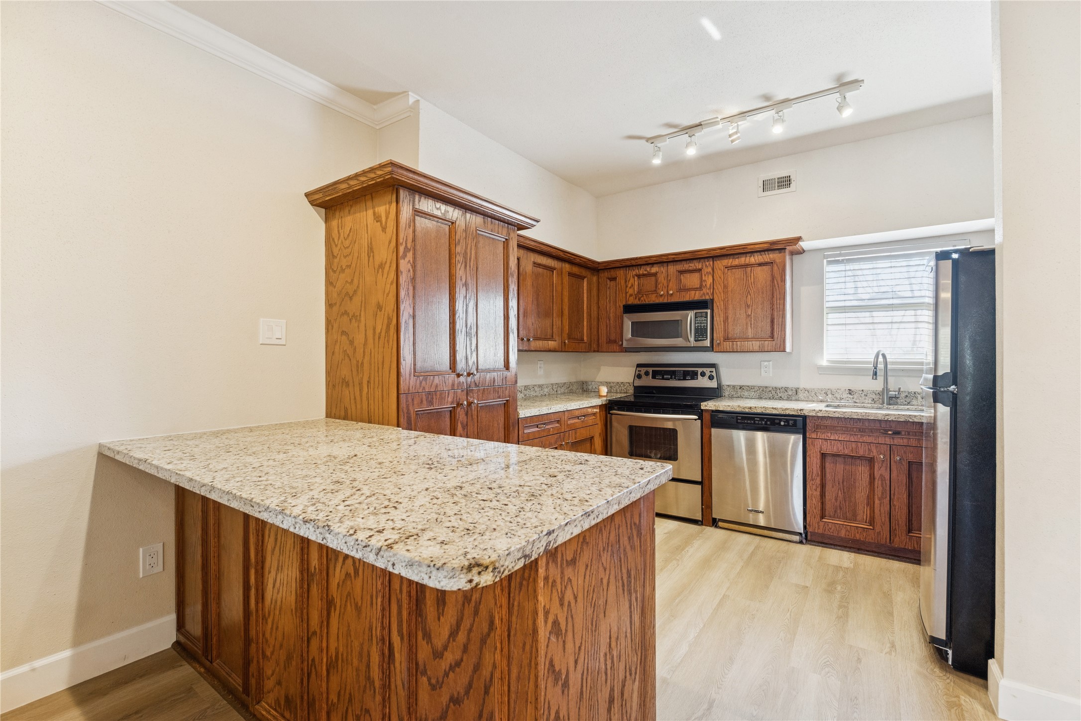 4041 Law Street, Unit 512 Houston, TX 77005 - Photo 5 of 15 a kitchen with granite countertop a sink appliances cabinets and counter space
