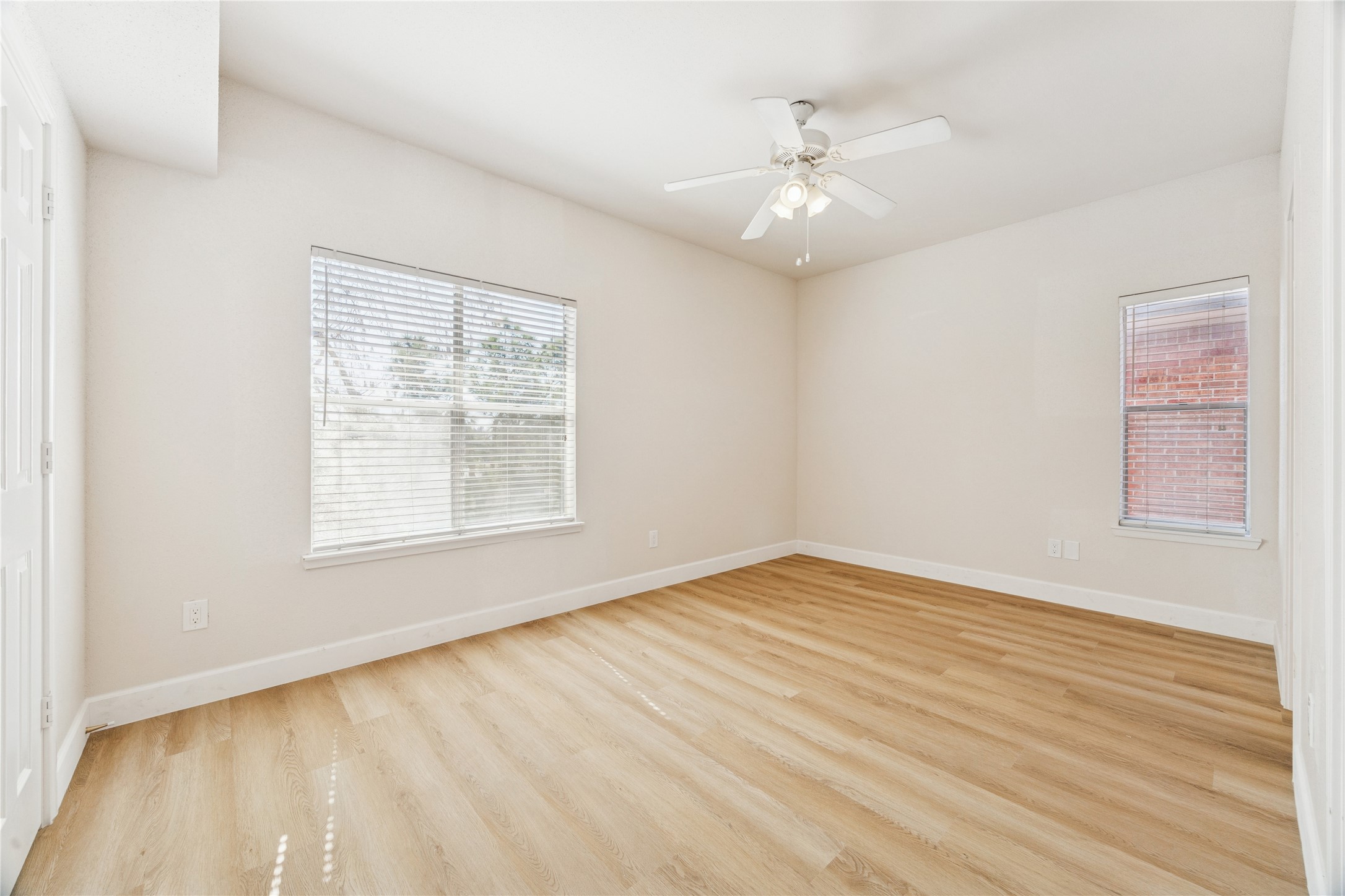4041 Law Street, Unit 512 Houston, TX 77005 - Photo 7 of 15 an empty room with wooden floor chandelier fan and windows