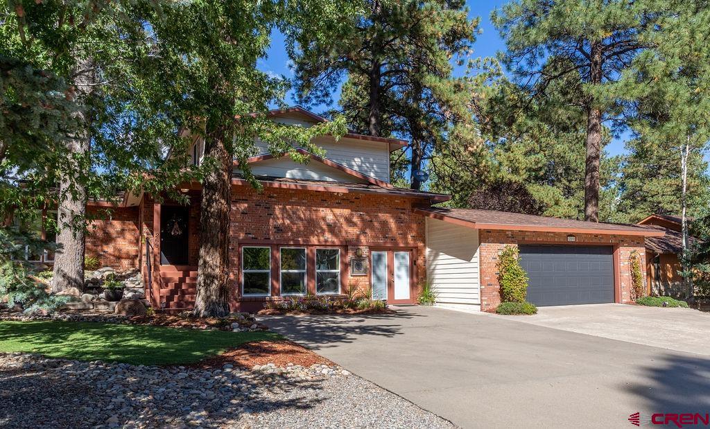 a view of a house with a yard and tree s