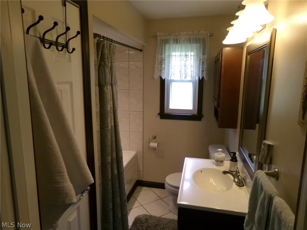 1912 Pickle Road Akron, OH 44312 - Photo 9 of 26 Full bathroom featuring tile flooring, vanity, shower / bath combo, and toilet
