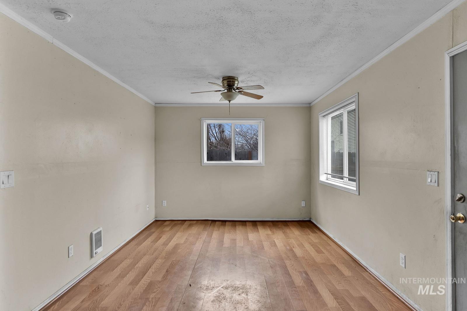 4715 West Reeves Street Coeur D'Alene, ID 83814 - Photo 4 of 24 Spare room featuring light wood-style floors, ceiling fan, a textured ceiling, and ornamental molding