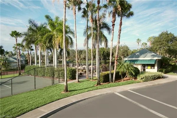 a view of a house with a yard and palm trees