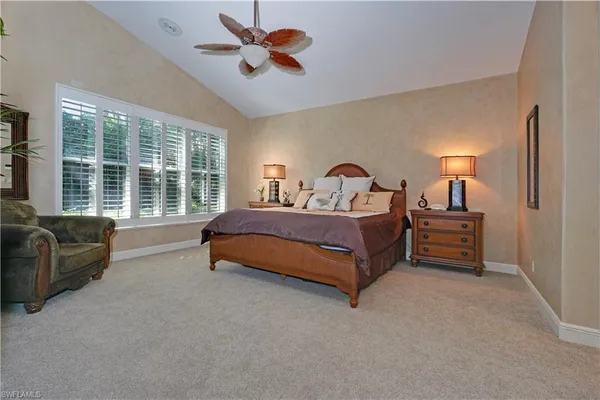 a spacious bedroom with a bed a couch and a large window