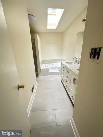 a bathroom with a tub sink and mirror