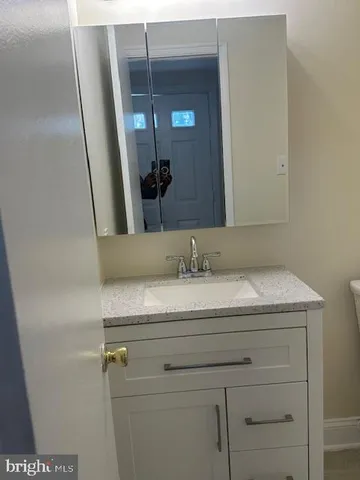 a bathroom with a granite countertop sink a mirror and vanity