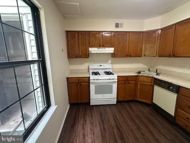 a kitchen with a white stove top oven sink and window