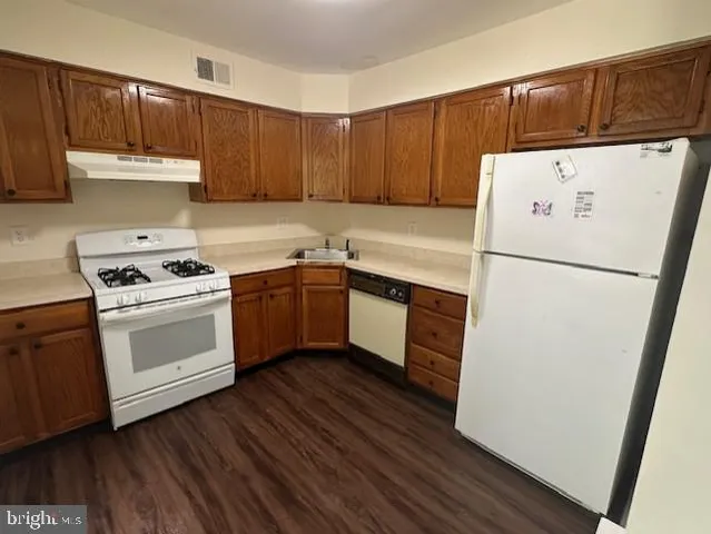 a kitchen with a white stove top oven and refrigerator