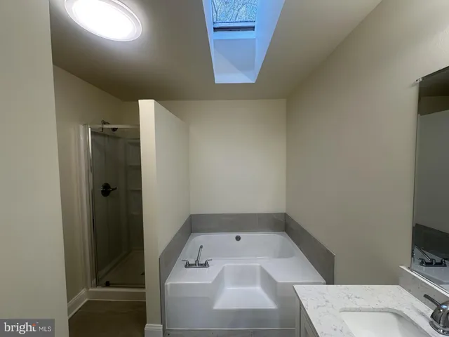 a bathroom with a tub double vanity sink and a mirror