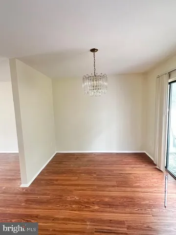 a view of a room with wooden floor and chandelier