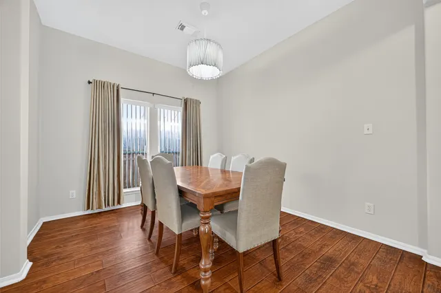 a view of an empty room with wooden floor and a fireplace