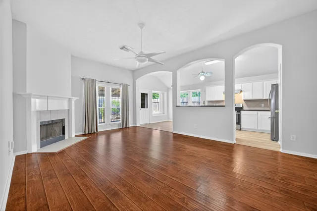 an empty room with wooden floor and windows
