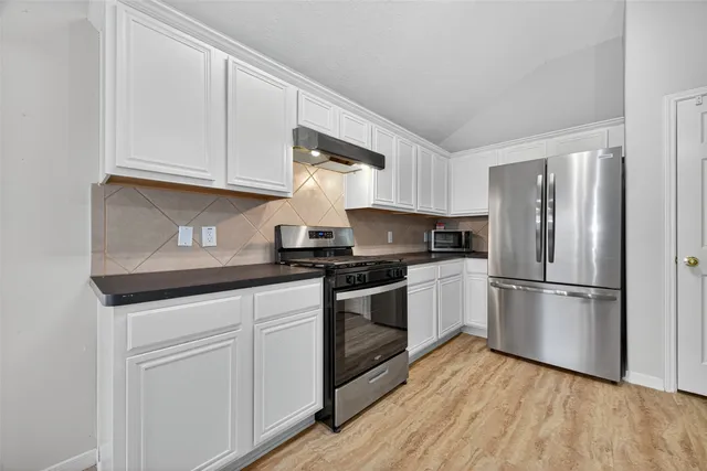 a kitchen with a sink and wooden floor