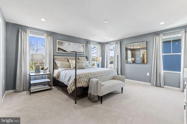 a bedroom with a bed lamp and a large window