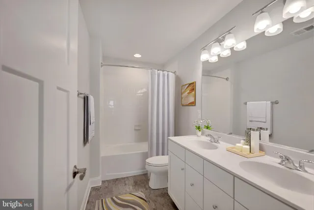 a bathroom with a granite countertop sink toilet a large mirror a shower and a mirror