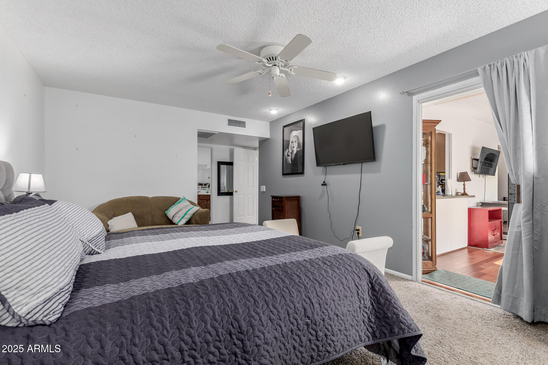 10023 West Pleasant Valley Road Sun City, AZ 85351 - Photo 13 of 41 a bedroom with a bed and a flat screen tv