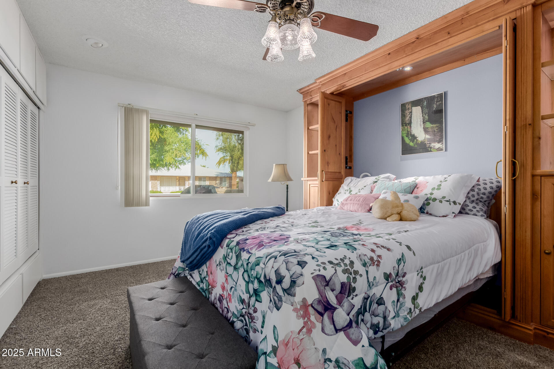 10023 West Pleasant Valley Road Sun City, AZ 85351 - Photo 16 of 41 a bedroom with a bed and a chandelier