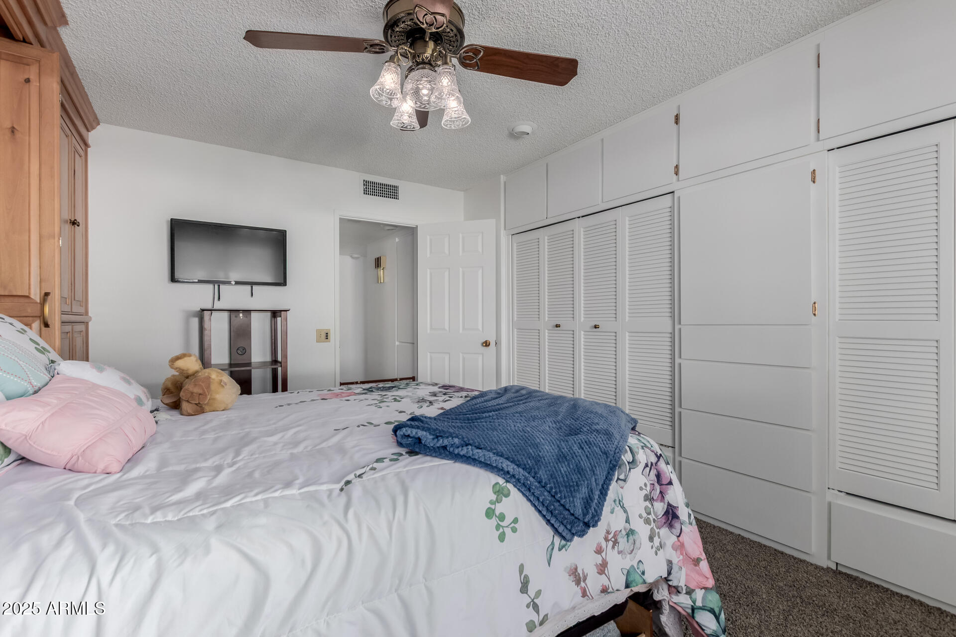 10023 West Pleasant Valley Road Sun City, AZ 85351 - Photo 17 of 41 a bedroom with a bed and a chandelier