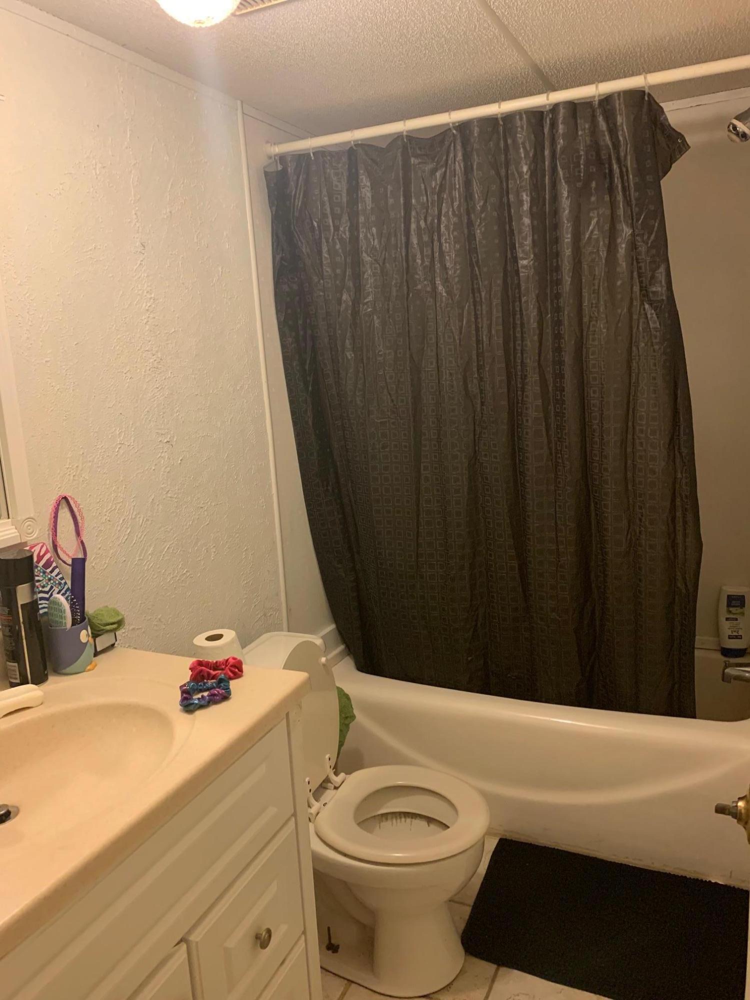 725 Squirrel Road DeFuniak Springs, FL 32433 - Photo 14 of 14 a bathroom with a sink a toilet and shower curtain