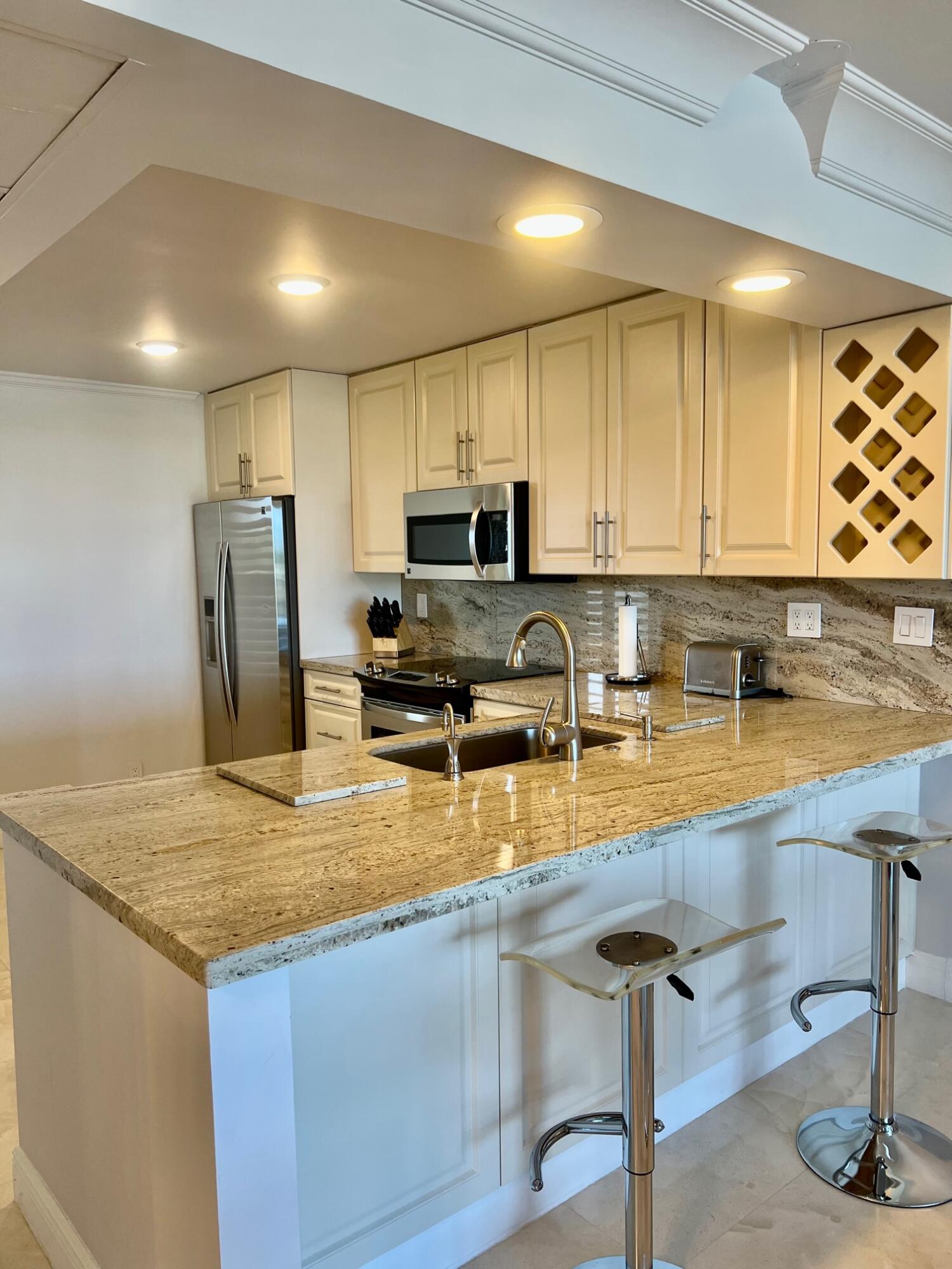 a kitchen with stainless steel appliances granite countertop a sink a stove and a refrigerator