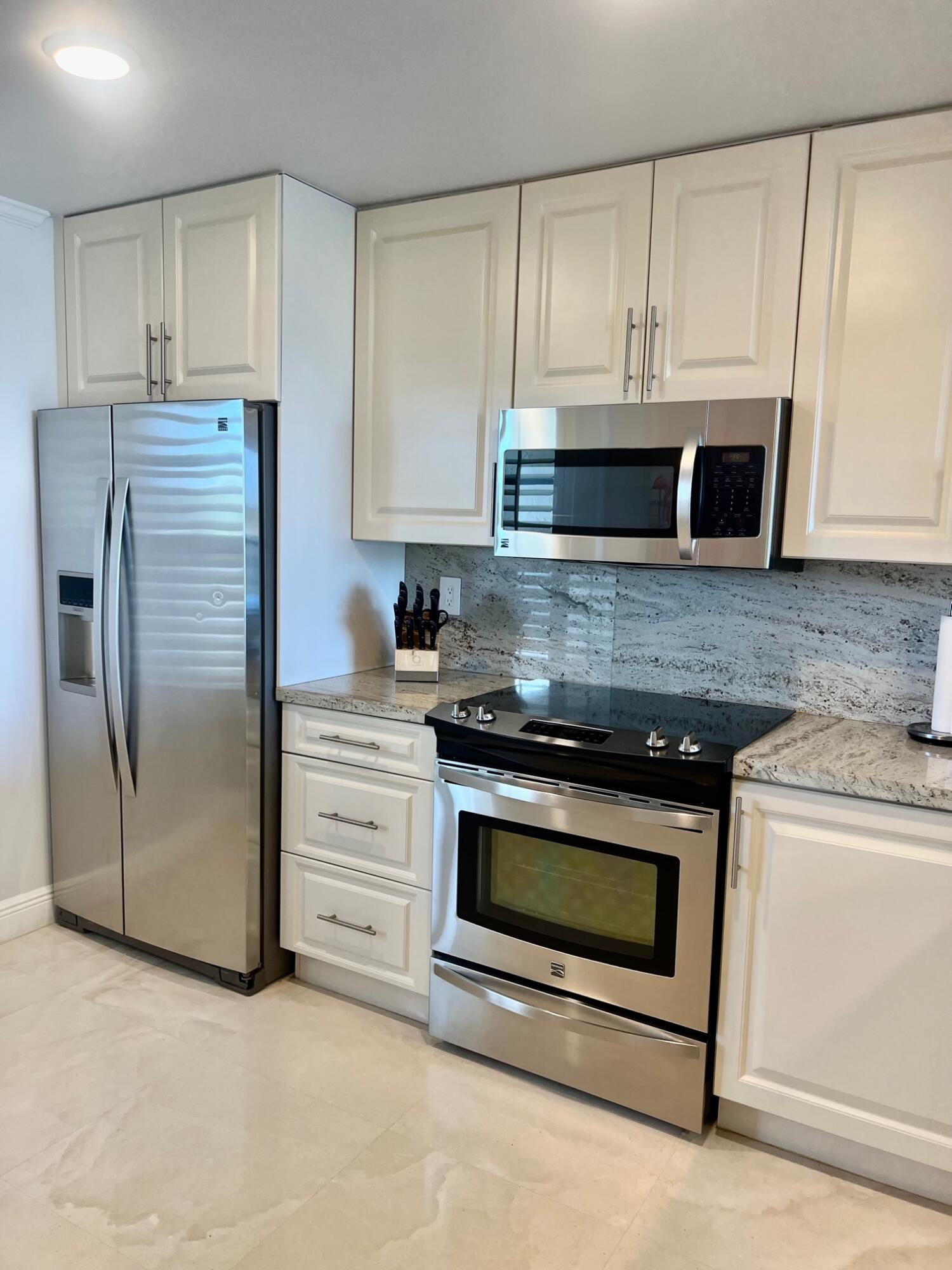 6 Royal Palm Way, Unit 607 Boca Raton, FL 33432 - Photo 2 of 16 a kitchen with stainless steel appliances granite countertop white cabinets a microwave a sink and a refrigerator