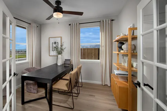 a view of a workspace with furniture and a window