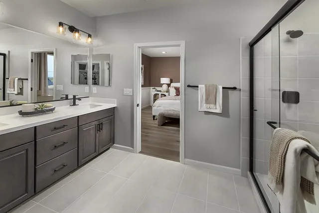 a en suite bathroom with a double vanity sink a large mirror and shower