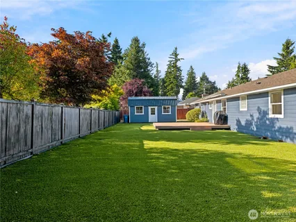 a view of a house with backyard and a tree