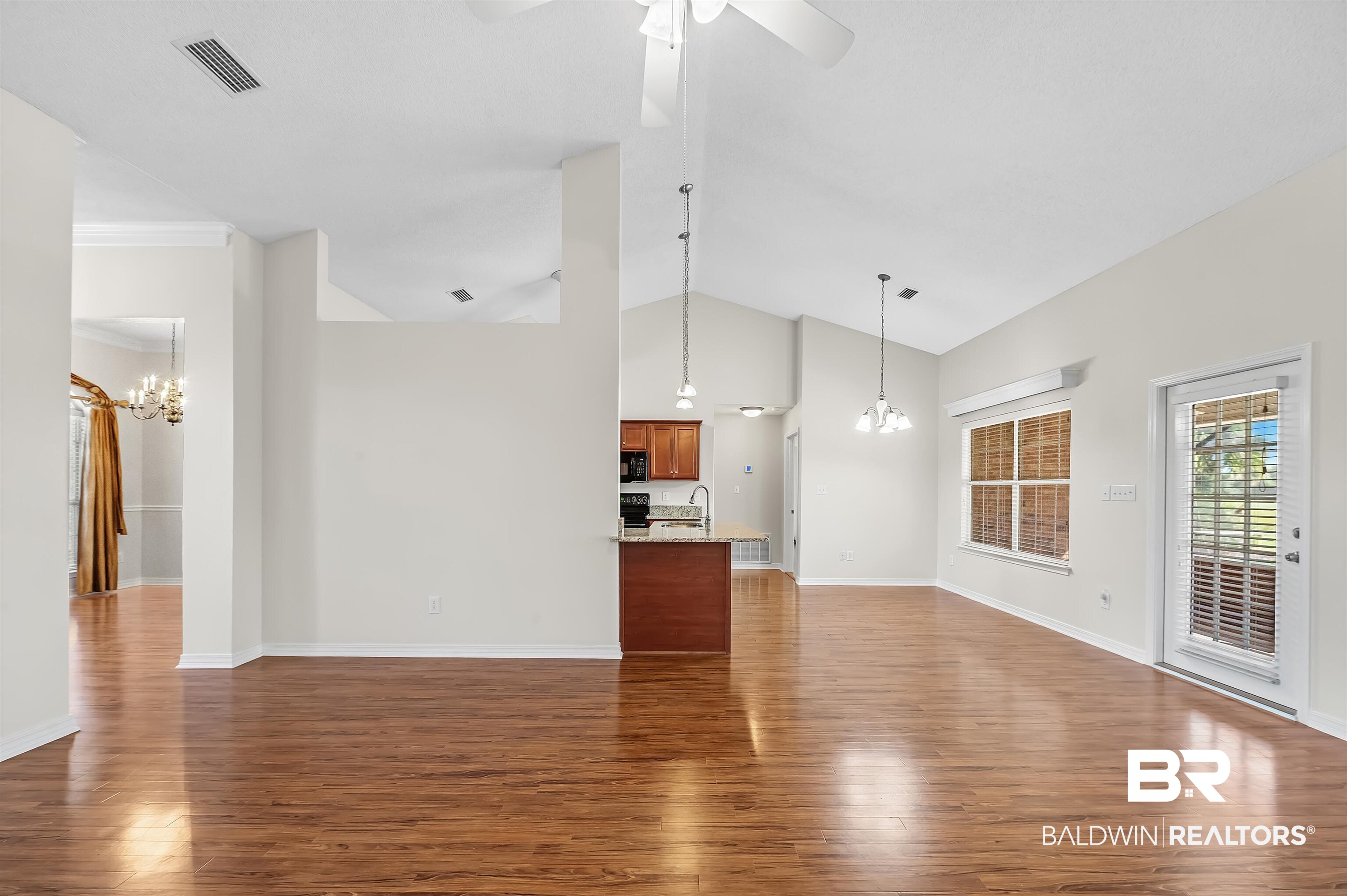 421 Collinwood Loop Foley, AL 36535 - Photo 44 of 62 Unfurnished living room featuring crown molding, high vaulted ceiling, sink, and dark hardwood / wood-style flooring