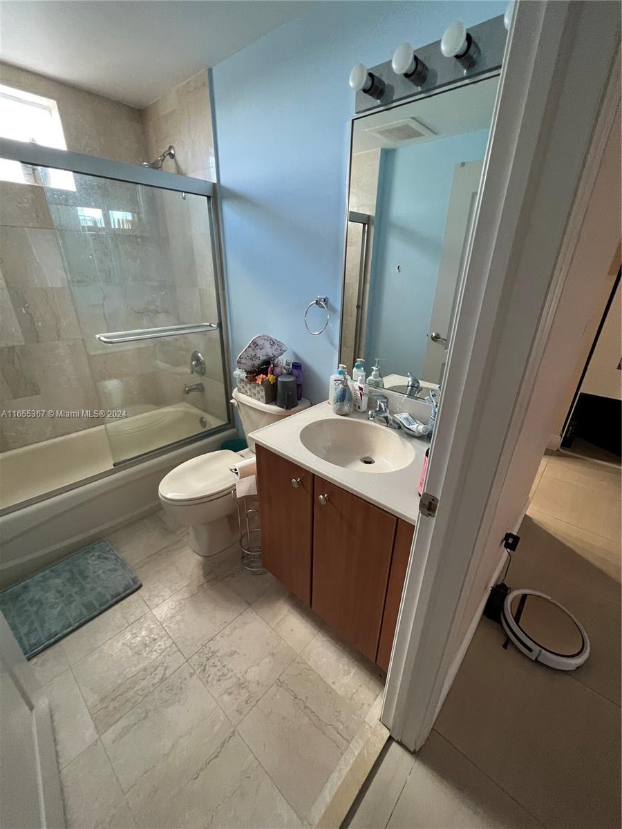 2550 Southwest 27th Avenue, Unit 703 Miami, FL 33133 - Photo 13 of 18 a bathroom with a sink a toilet a mirror and shower