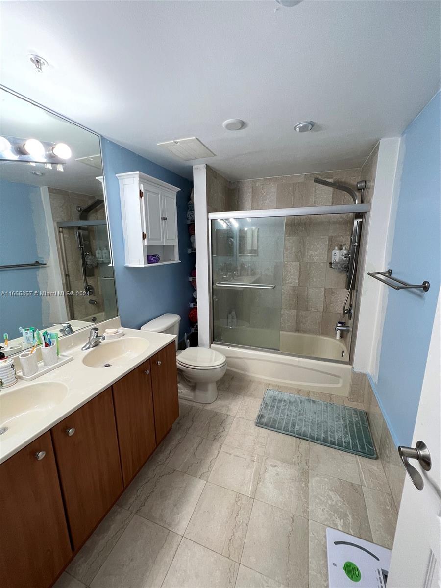 2550 Southwest 27th Avenue, Unit 703 Miami, FL 33133 - Photo 5 of 18 a bathroom with a bathtub shower sink and mirror