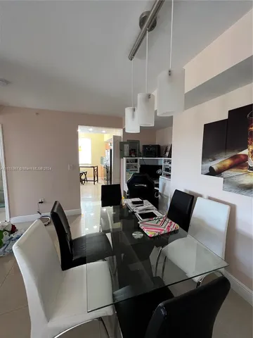 a living room with furniture a flat screen tv and kitchen view