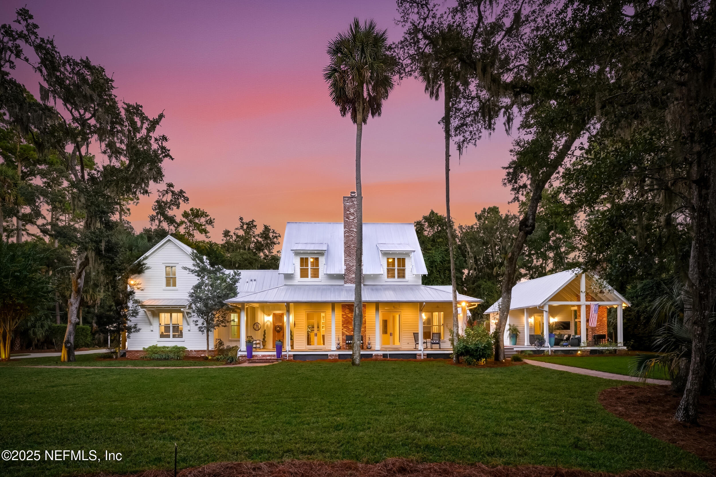 a front view of a house with a garden and trees