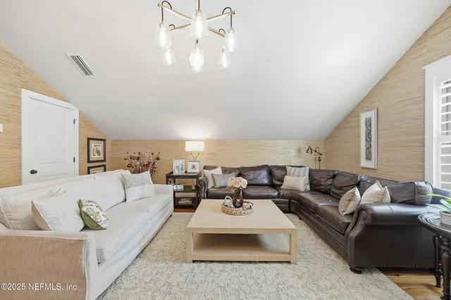an aerial view of a houses with a lush green hillside