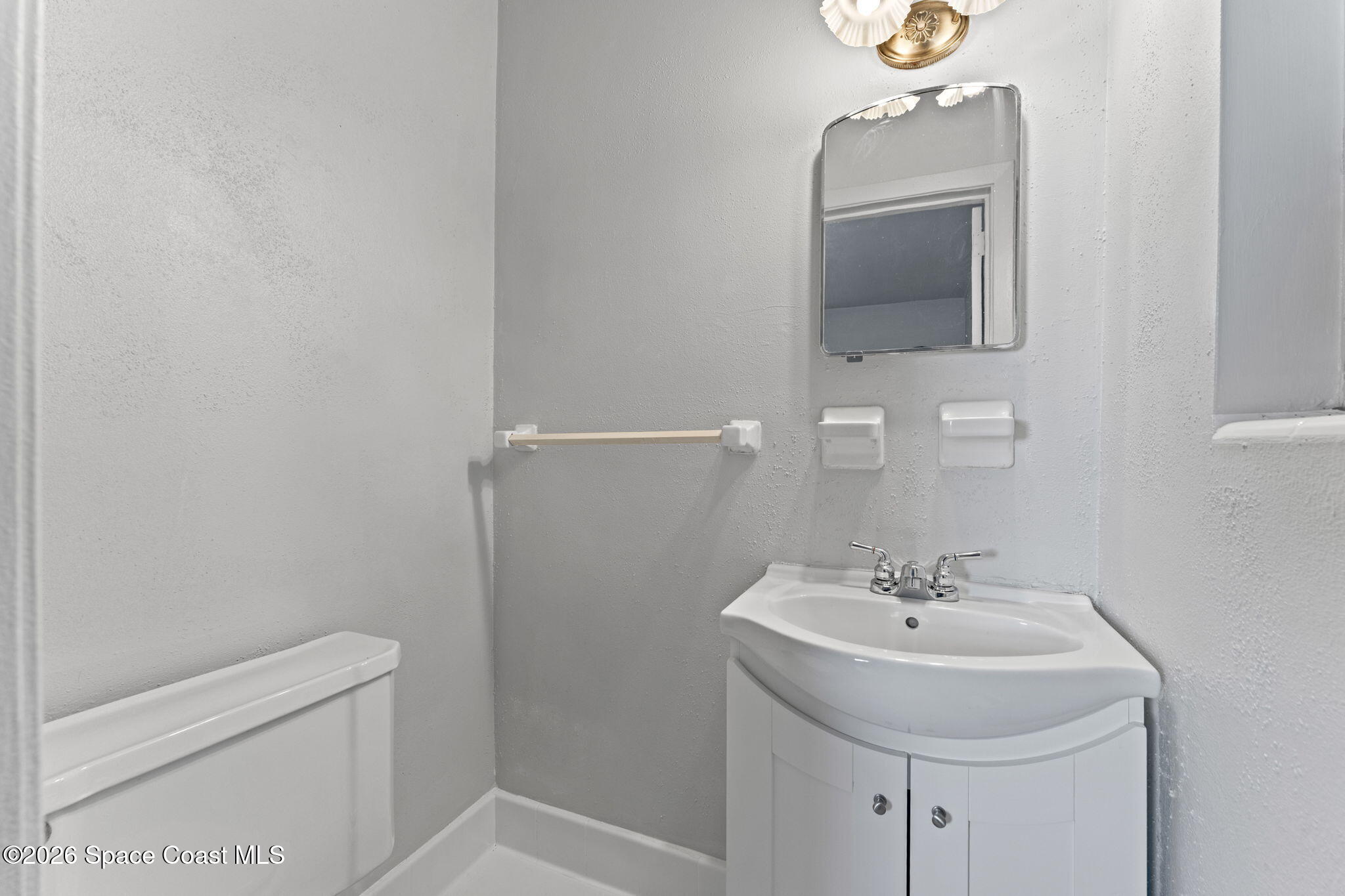 1042 Azalea Lane Cocoa, FL 32922 - Photo 18 of 26 a bathroom with a sink toilet and mirror