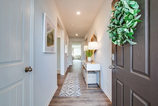 a view of a hallway with wooden floor and a potted plant