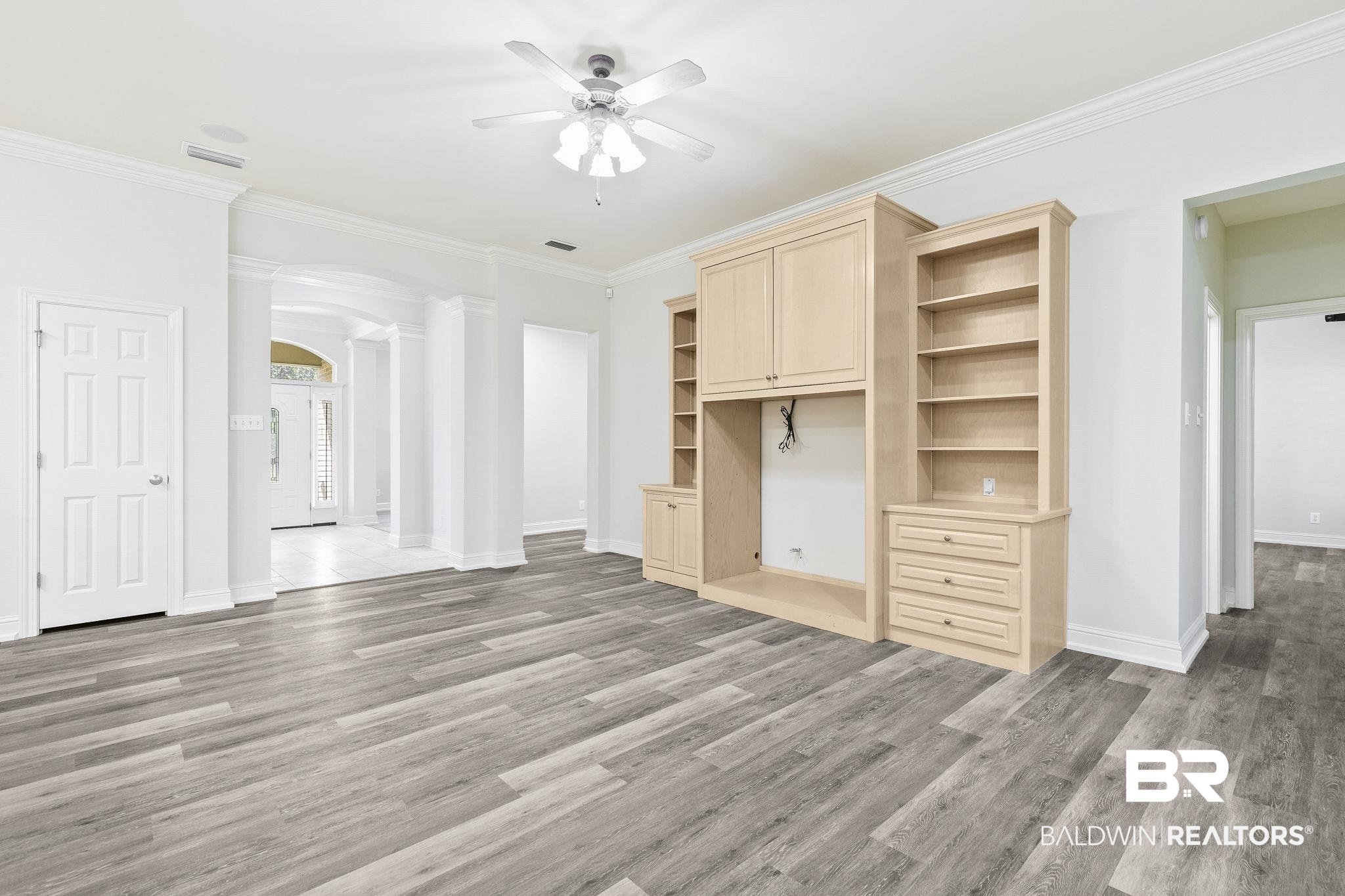 13 Bugle Retreat Daphne, AL 36527 - Photo 8 of 40 Unfurnished living room featuring decorative columns, crown molding, hardwood / wood-style floors, and ceiling fan