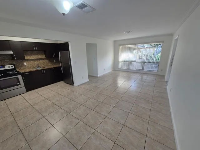 a kitchen with granite countertop a sink cabinets and a stove top oven