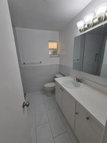 a bathroom with a sink a toilet and mirror