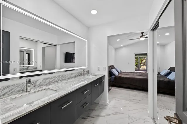 a en suite bathroom with a granite countertop sink and a mirror