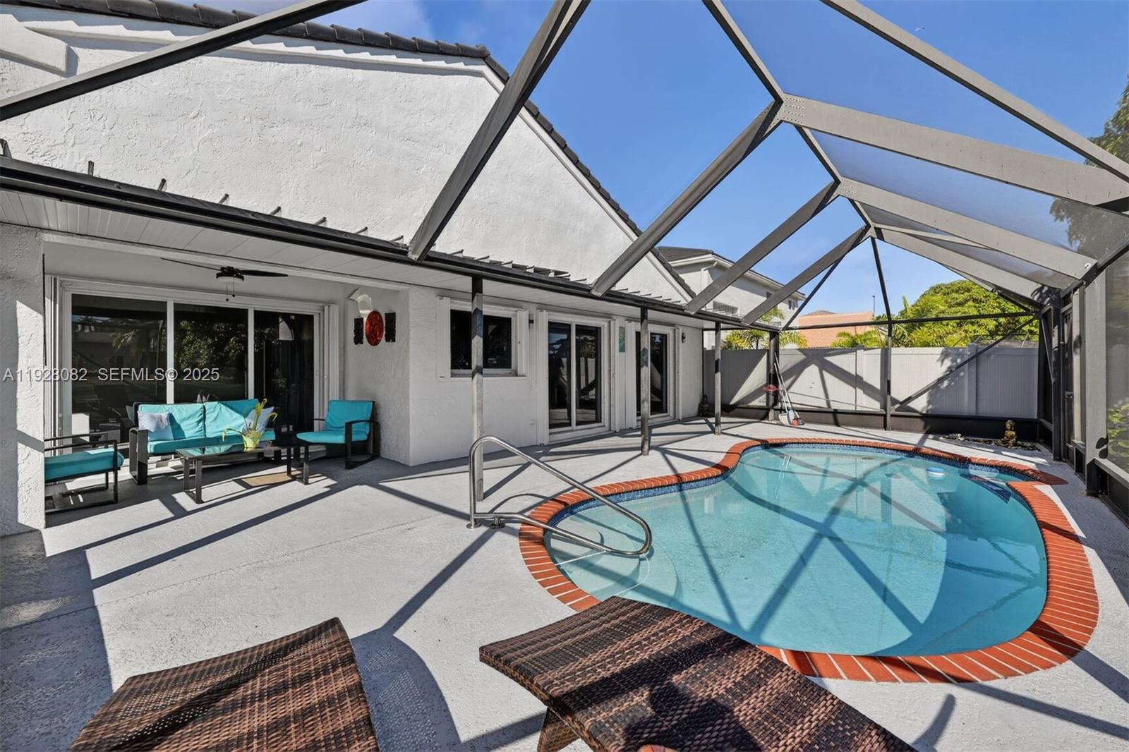 720 Rock Hill Avenue Davie, FL 33325 - Photo 18 of 27 a view of a patio with table and chairs under an umbrella