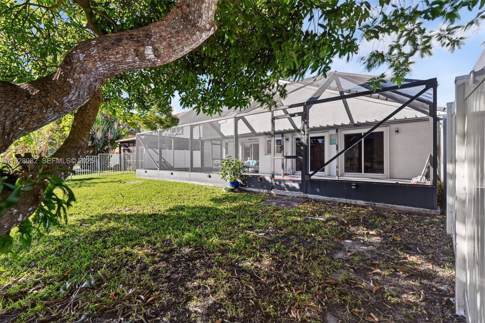 720 Rock Hill Avenue Davie, FL 33325 - Photo 24 of 27 a view of a house with a small yard and a large tree
