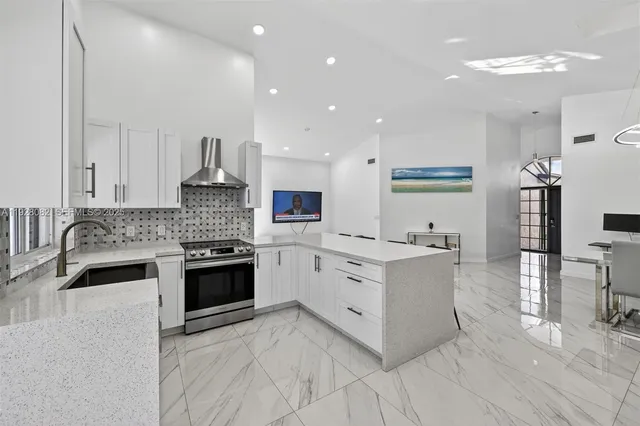 a kitchen with white cabinets and appliances