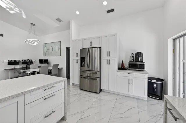 a kitchen with a refrigerator and a stove top oven